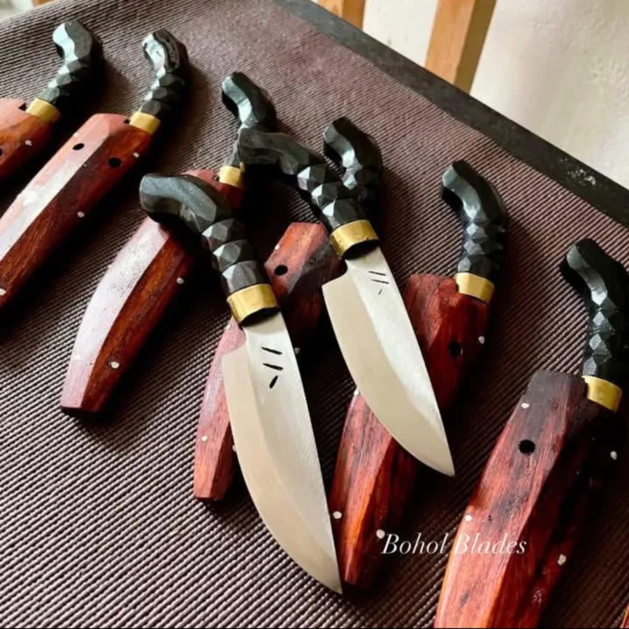 Faceted carabao horn handles with brass ferrules on a row of kitchen knives