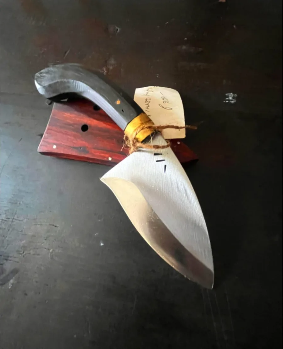 A small kitchen knife resting on its rosewood sheath